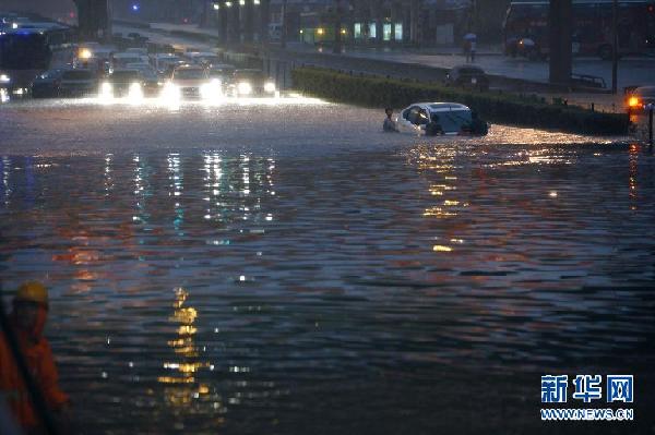 7月21日，在北京市莲花桥，一辆汽车即将被雨水淹没。当日，北京遭遇强降雨。18时30分，北京市气象台发布暴雨橙色预警。 新华社发（万象）